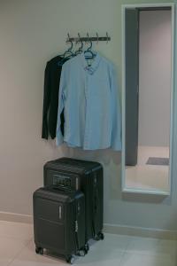 a suitcase and a shirt hanging on a clothes rack at Bluewaters Collab Quarters in Singapore