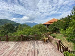 una terraza de madera con una maceta. en Hulu Tamu Off Grid Morrocan styled Hill Top Villa, en Kampong Sungai Tamu