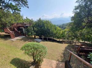 un giardino con panchine e vista sulle montagne di Hulu Tamu Off Grid Morrocan styled Hill Top Villa a Kampong Sungai Tamu