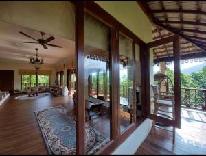 uma ampla sala de estar com uma ventoinha de tecto e portas de vidro em Hulu Tamu Off Grid Morrocan styled Hill Top Villa em Kampong Sungai Tamu