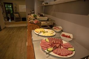 una línea de buffet con diferentes tipos de carne y queso en WannerHus Hotel, en Grömitz