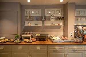 a kitchen with a counter with plates of food on it at WannerHus Hotel in Gr&ouml;mitz