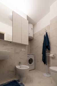 a bathroom with a sink and a washing machine at Sunny Home, appartamento in centro e vicino alla spiaggia in Grado