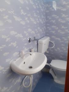 a bathroom with a sink and a toilet at Paul's Inn in Silchar