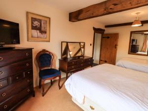 1 dormitorio con 1 cama y vestidor con espejo en Scales Cottage en Lorton
