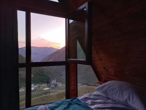 a bedroom with a window looking out at the mountains at Cottage Hillside in Juta in Jut'a +19 photos