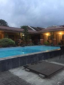 - une piscine en face d'une maison la nuit dans l'établissement Roemah kita hotel, à Ngaglik
