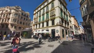 un grupo de personas caminando por una calle de la ciudad con edificios en Del Parque Flats Calle Nueva Quiet, en Málaga