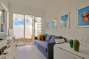 sala de estar con sofá azul y cocina en 2 Bedroom House Situated at the Centre of Surry Hills 2 E-Bikes Included, en Sídney