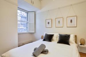 a bedroom with a large white bed with a window at 2 Bedroom House Situated at the Centre of Surry Hills 2 E-Bikes Included in Sydney