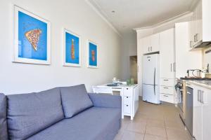 a living room with a blue couch and a kitchen at 2 Bedroom House Situated at the Centre of Surry Hills 2 E-Bikes Included in Sydney