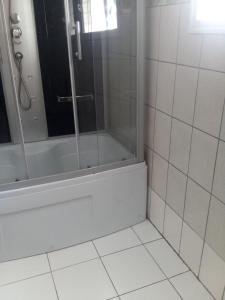 baño con ducha y puerta de cristal en Hôtel LE CARRE D'AS MANDROSOA IVATO, en Ivato