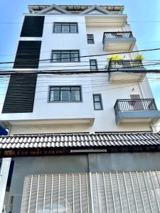 a tall white building with windows and balconies at LSP Hotel & Apartment in Phnom Penh