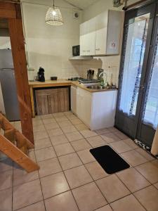 eine Küche mit Spüle und Fliesenboden in der Unterkunft Maison calme proche étang in La Coquille