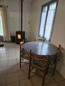 - une table avec deux chaises et une cuisinière dans la chambre dans l'établissement Maison calme proche étang, à La Coquille