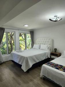 una camera con due letti e una finestra di Casa Emanuel Frente al lago a Sololá