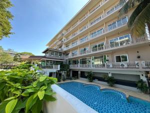 a hotel with a swimming pool in front of a building at Rattana View in Phitsanulok