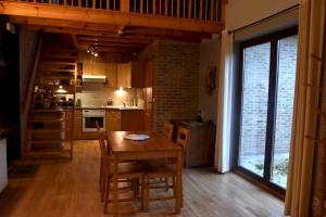 uma cozinha com mesa e cadeiras num quarto em 2 bedrooms appartement with private pool terrace and wifi at Ottignies Louvain la Neuve em Limelette