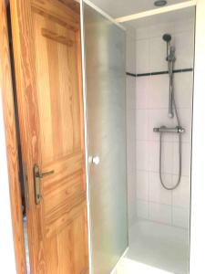 La salle de bains est pourvue d'une douche et d'une porte en bois. dans l'établissement 2 bedrooms apartement with private pool terrace and wifi at Ottignies Louvain la Neuve, à Limelette