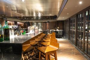 - un bar avec des chaises en bois et des bouteilles de vin dans l'établissement Sheraton Taitung Hotel, à Taïtung