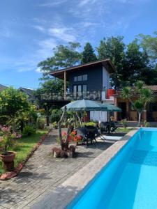een villa met een zwembad en een huis bij Roemah kita hotel in Ngaglik