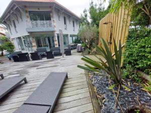 een houten terras met banken voor een huis bij Villa de 5 chambres a Arcachon a 400 m de la plage avec piscine interieure et wifi in Arcachon