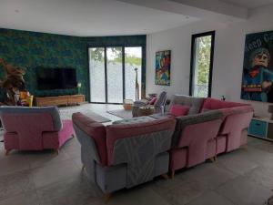 een woonkamer met 2 banken en een televisie bij Villa de 5 chambres a Arcachon a 400 m de la plage avec piscine interieure et wifi in Arcachon