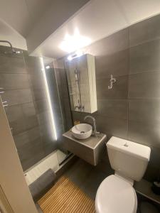 a bathroom with a white toilet and a sink at SnD Rentals- Studios in Kozani