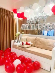 a room with red and white balloons and a couch at Nordic 1BR in Twin Lakes Tagaytay LL3-G in Tagaytay