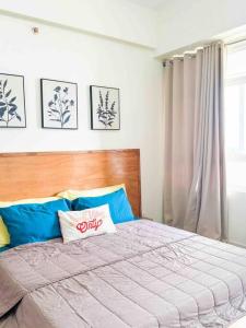 a bedroom with a large bed with a wooden headboard at Nordic 1BR in Twin Lakes Tagaytay LL3-G in Tagaytay