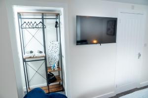 una camera con armadio, TV e mensola di Kings Arms Suites - Deluxe Room - En-Suite - Self Check In a Whitehaven