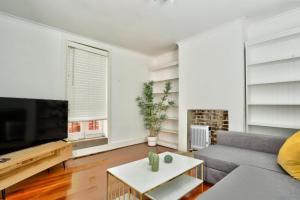 Close to City 3 Bedroom House Surry Hills 2 E-Bikes Included في سيدني: غرفة معيشة مع أريكة وتلفزيون