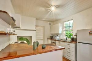 uma cozinha com armários brancos e um frigorífico branco em Close to City 3 Bedroom House Surry Hills 2 E-Bikes Included em Sydney
