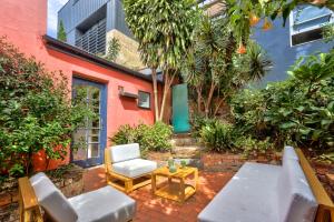 a patio with a couch and a chair and a table at Close to City 3 Bedroom House Surry Hills 2 E-Bikes Included in Sydney