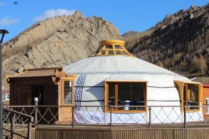 une maison en forme de dôme avec une montagne en arrière-plan dans l'établissement Khumug Tour Resort, à Yoliin Hural
