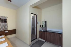 a room with a kitchen with a mirror and a sink at Hotel Ambika in Kolhapur
