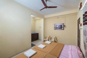 a room with a bed and a table and chairs at Hotel Ambika in Kolhapur