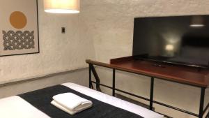 アレキパにあるStudio Room with 2 Beds in Vibrant Arequipa Cityのベッド1台、薄型テレビが備わる客室です。