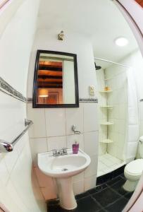 a bathroom with a sink and a mirror and a toilet at Studio Room with 2 Beds in Vibrant Arequipa City in Arequipa