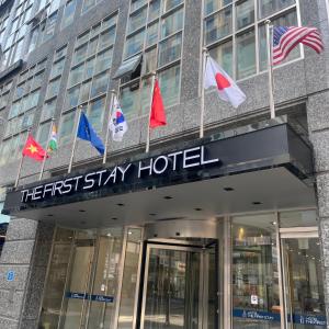 a hotel with flags on the front of a building at First Stay Hotel in Seoul