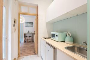 a kitchen with a sink and a microwave on a counter at Studio Centre-ville Sur Cour in Toulouse