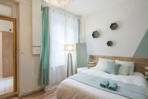 a bedroom with a bed with two blue towels on it at Studio Centre-ville Sur Cour in Toulouse