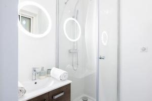a white bathroom with a shower and a sink at Studio Centre-ville Sur Cour in Toulouse