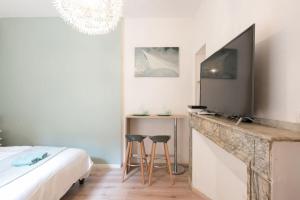 a bedroom with a bed and a fireplace with a tv at Studio Centre-ville Sur Cour in Toulouse