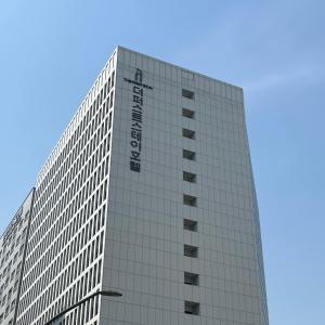 ソウルにあるFirst Stay Hotelの看板が横に建つ高層ビル
