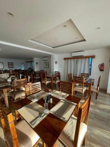 a large dining room with wooden tables and chairs at The Bodhgaya Hotel School in Bodh Gaya