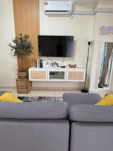 uma sala de estar com um sofá e uma televisão de ecrã plano em Orked Homestay em Bagan Serai