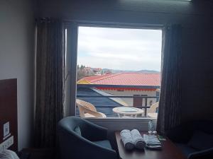 een kamer met een raam met een bank en een tafel bij Blue Lotus by M - Resort and Camps in Mukteswar