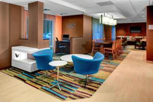 a lobby with a table and chairs and a dining room at Fairfield Inn & Suites by Marriott Atlanta Alpharetta in Alpharetta