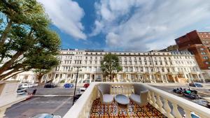 a balcony with tables and chairs on a city street at MSK Elite in London